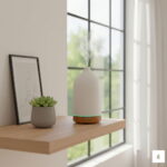 Biały ceramiczny dyfuzor PureSense na drewnianej półce, prezentacja rozmiaru urządzenia w relacji do dłoni